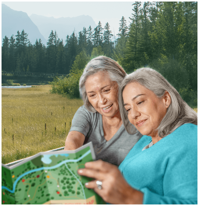 Two women reading a map in a park.